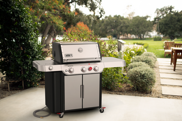 Weber grill with a beautiful garden background